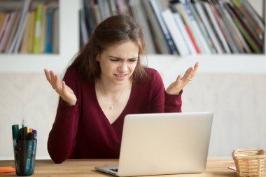 Frustrated annoyed woman confused by computer problem looking at clipart