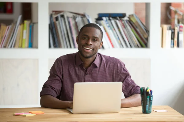 Afro-amerikansk affärsman sitter vid skrivbord med laptop söker — Stockfoto