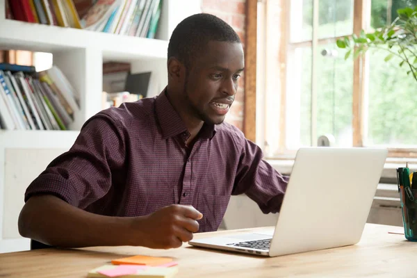 Joven afroamericano hombre mirando a la computadora portátil frustrado por el mal n —  Fotos de Stock
