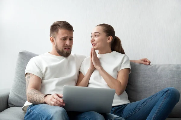 Esposa con las manos suplicantes pidiendo marido comprar regalo caro en línea — Foto de Stock