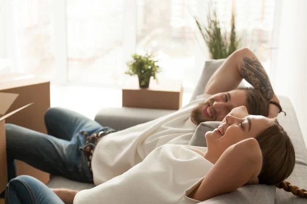 Felice coppia rilassante sul divano ridendo divertirsi il giorno in movimento — Foto Stock