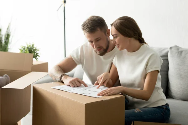 Young couple discussing house plan just moved in new home