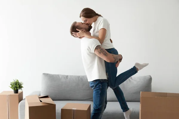 Pareja cariñosa besándose emocionada por mudarse a un nuevo hogar — Foto de Stock