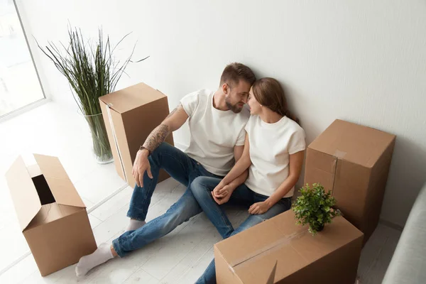 Pareja joven que se une sentada en el suelo con cajas móviles — Foto de Stock