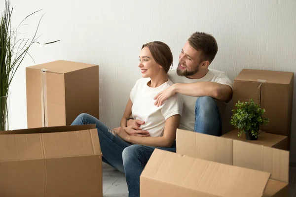 Young couple embracing looking forward to future in new home — Stock Photo, Image