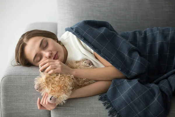 Wanita kekanak-kanakan tidur di sofa yang nyaman dengan boneka — Stok Foto