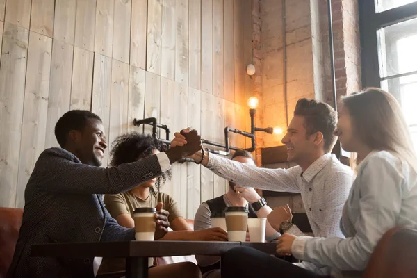 Африканские и кавказские мужчины пожимают руку на встрече в кофейне — стоковое фото