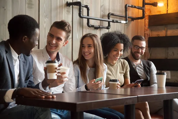 Feliz grupo multiétnico de amigos hablando con teléfonos inteligentes en —  Fotos de Stock