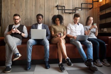 Sırada oturan farklı gençler cihazlar ile online takıntılı