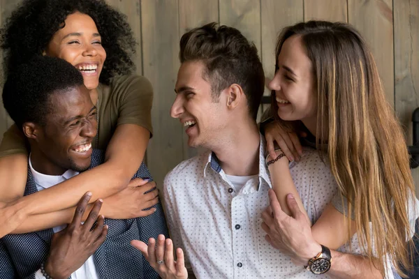 Sahip kucaklayan iki mutlu Afrika ve beyaz çiftler eğlenceli TOG yardımı — Stok fotoğraf