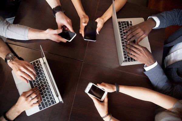 Различные многорасовые люди, использующие ноутбуки смартфоны на столе, т
