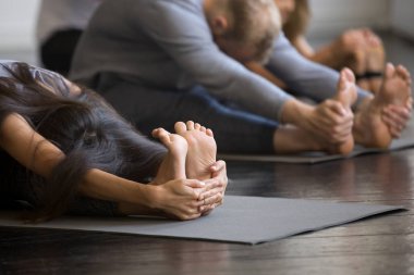 Paschimottanasana poz sportif gençlerin grup, yakın çekim