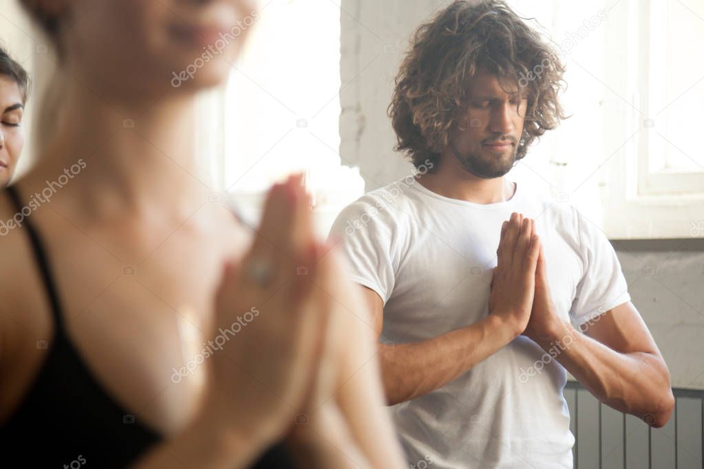 Group of young sporty people make namaste gesture, closeup
