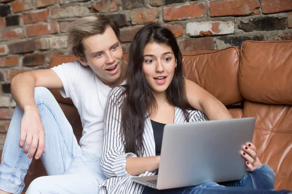 Surprised couple looking at laptop amazed by unbelievable online — Stock Photo, Image