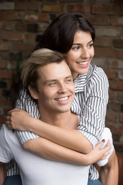 Young millennial couple in love embracing looking forward to fut