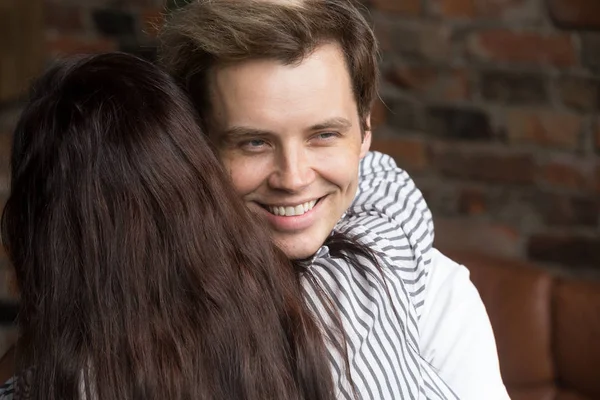 Young sly liar man happily smiling while woman embracing him — Stock Photo, Image