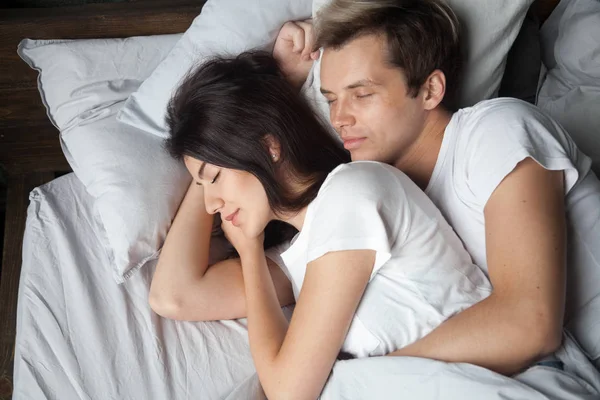 Молодая пара спит вместе, обнимая лежащего спящего в комфорте — стоковое фото