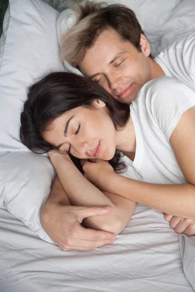 Beautiful young couple sleeping in bed at home together, vertica — Stock Photo, Image