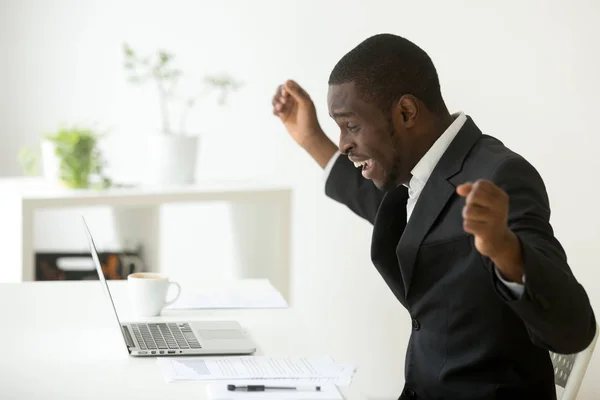 Happy african-american businessman celebrating success online wi — Stock Photo, Image