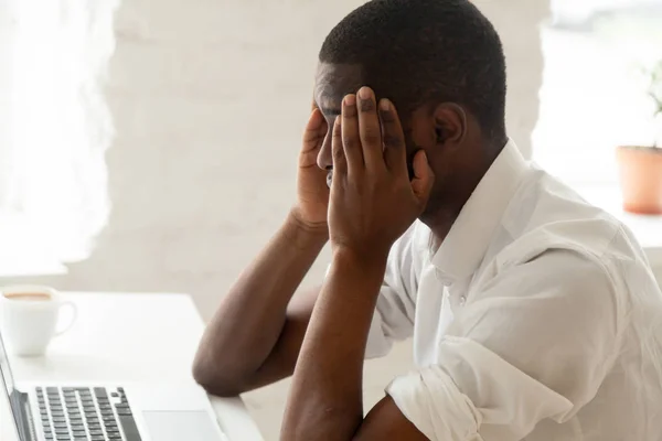 Homme d'affaires afro-américain se sentant mal à la tête au travail touchant t — Photo