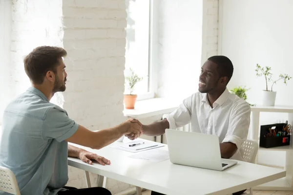 African american and caucasian businessmen shaking hands over of — Stock Photo, Image