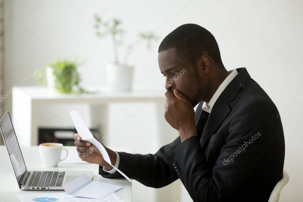 Shocked stressed african-american businessman frustrated by noti