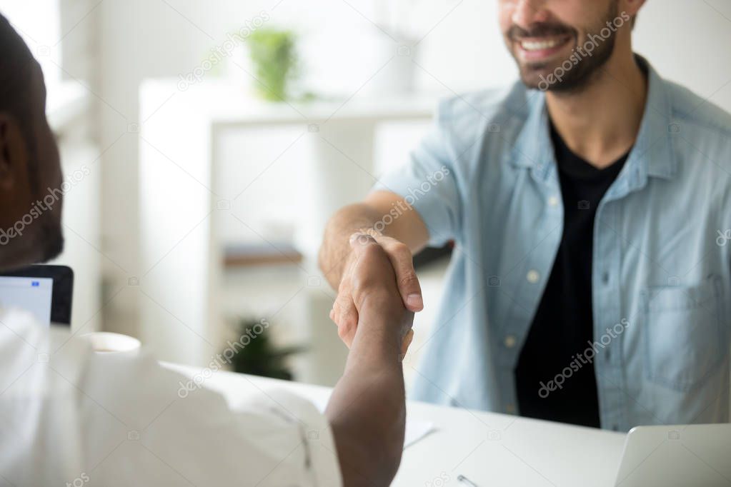 Multiracial businessmen shaking hands, multi-ethnic partnership 