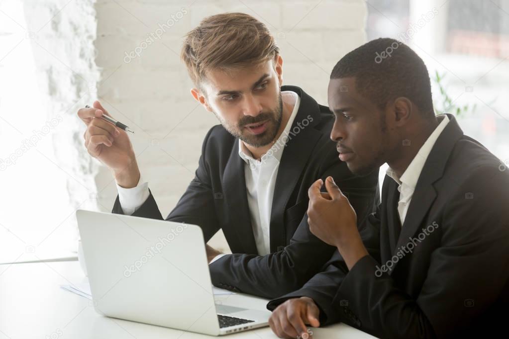 African and caucasian businessmen discussing online project idea