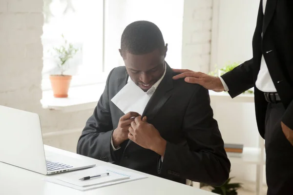 Zwarte zakenman, envelop in zak ontvangende omkopen of b verbergen — Stockfoto