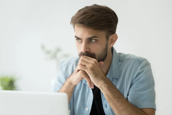 Thoughtful serious man lost in thoughts in front of laptop — Stock Photo, Image