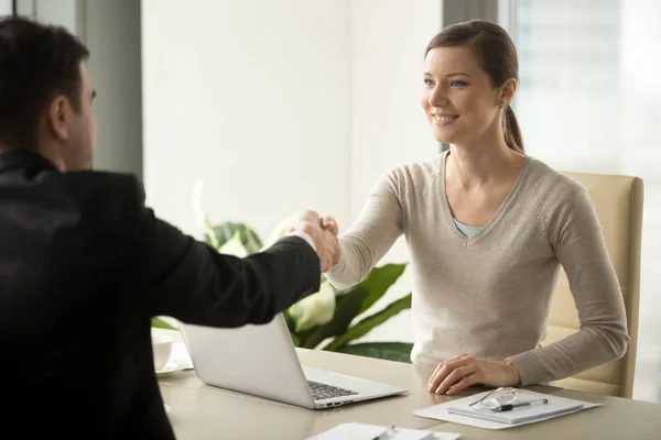 Female employee handshaking with male client — Stock Photo, Image