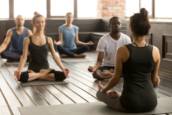 Sportif gençler Sukhasana, dikiz oturma grubu