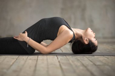 Genç kadının Matsyasana egzersiz yapması kadar yakın