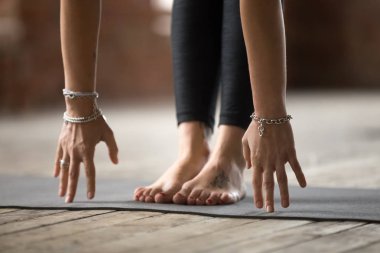 Genç kadın Uttanasana egzersiz yaparak