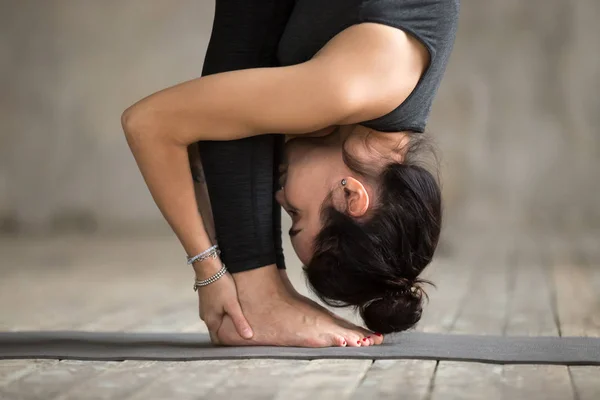 Mladá žena, která dělá uttanasana cvičení, zblizka — Stock fotografie
