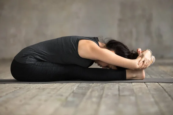 Unga yogi kvinna gör paschimottanasana övning — Stockfoto