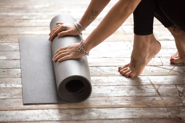 Vrouw uitrollen oefening mat om te beginnen met fitness praktijk — Stockfoto