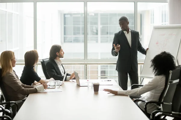 Entrenador negro dando presentación a los clientes en la reunión de la conferencia —  Fotos de Stock