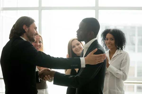Chefe da empresa promovendo empregado afro-americano com aperto de mão — Fotografia de Stock