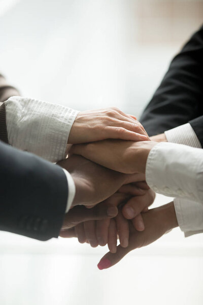 Упакованная кучка рук закрывает вертикальный взгляд, мотивированная многонациональная бизнес-команда объединяется как концепция вовлечения и единства, обещая поддержку в сотрудничестве, помощи и приверженности в командной работе
