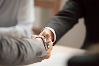 Grup toplantısında, ortaklar anlaşmasının müzakereleri anlaşma veya sözleşme, yardım destek için teşekkür tebrik el sıkışması kavramı Hoşgeldiniz, yakın çekim yapma, el sallayarak takım elbiseli iki iş adamları