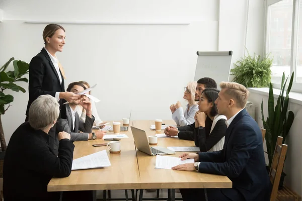 Successful female boss leading team meeting talking to multiraci
