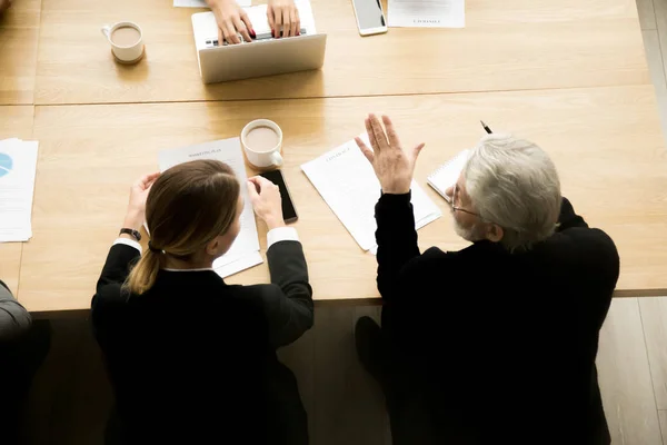 Senior businessman and businesswoman discussing contract deal at — Stock Photo, Image