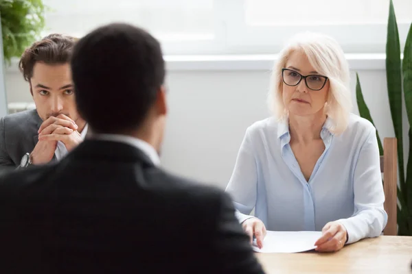 Serious attentive senior hr listening to candidate at job interv — Stock Photo, Image
