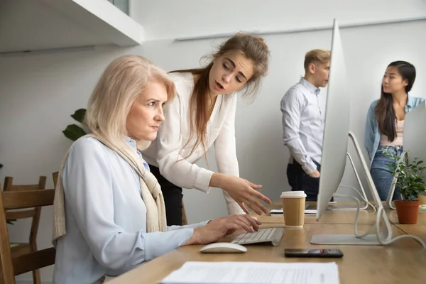 Young team leader correcting offended senior employee scolding f — Stock Photo, Image