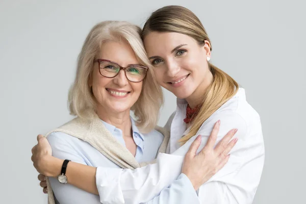 Glücklich ältere Mutter und erwachsene Tochter umarmen Blick auf Kamera — Stockfoto