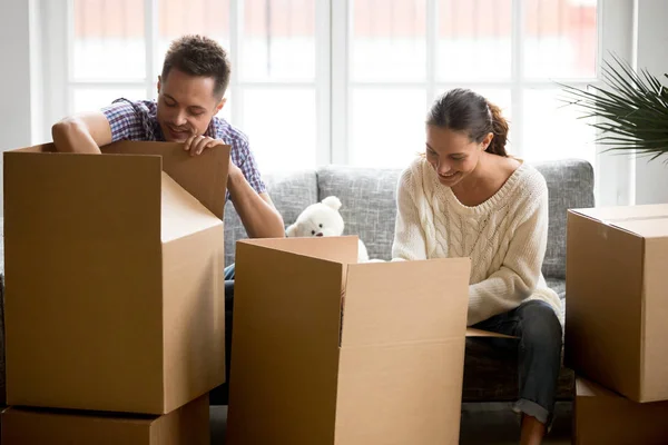 Young couple packing or unpacking boxes together, moving day con — Stock Photo, Image