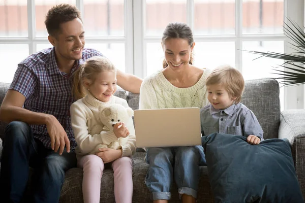 Gelukkige familie met kinderen met plezier gebruik van de laptop op de Bank — Stockfoto