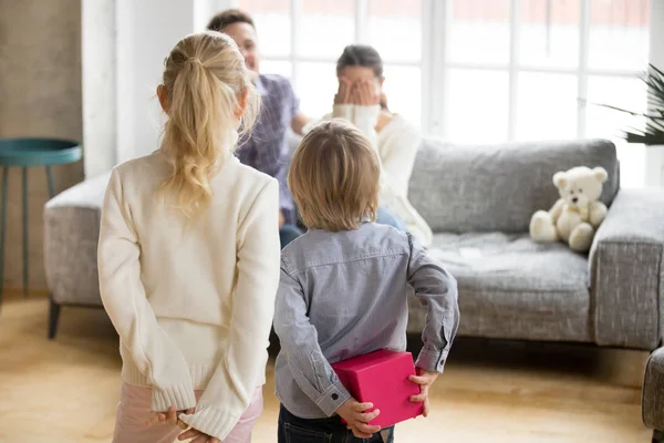 Bambini che fanno sorpresa alla mamma il giorno delle madri, vista posteriore — Foto Stock