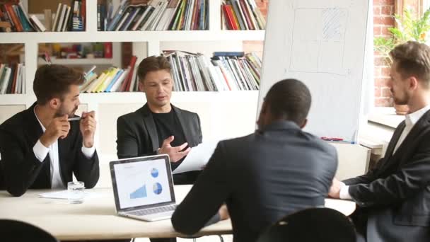 Socios masculinos multirraciales discutiendo documento de negocios en la reunión en la sala de juntas — Vídeo de stock
